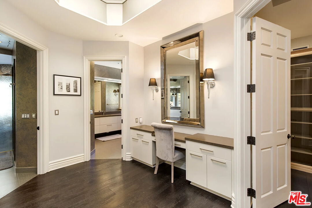 14132 Beresford Road Beverly Hills, CA 90210 - Photo 13 of 21 a room with white cabinets and clock on the wall