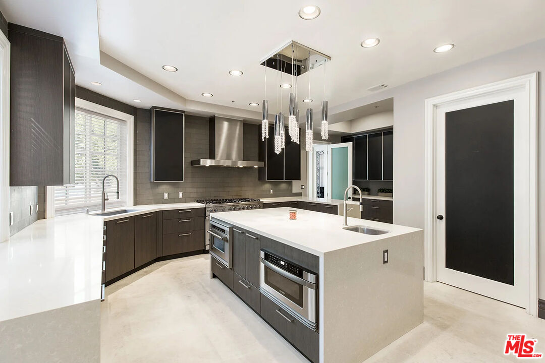 14132 Beresford Road Beverly Hills, CA 90210 - Photo 6 of 21 a large white kitchen with a stove and a sink