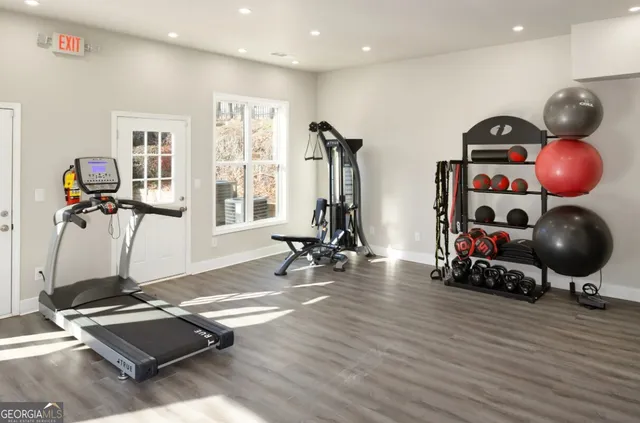 a room with gym equipment and wooden floor