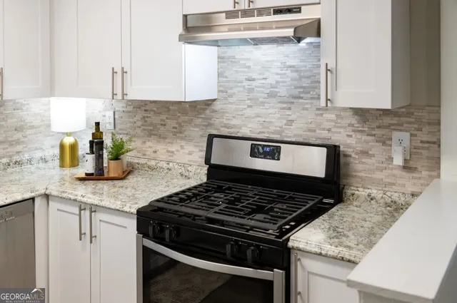 a kitchen with stainless steel appliances granite countertop a sink stove and cabinets