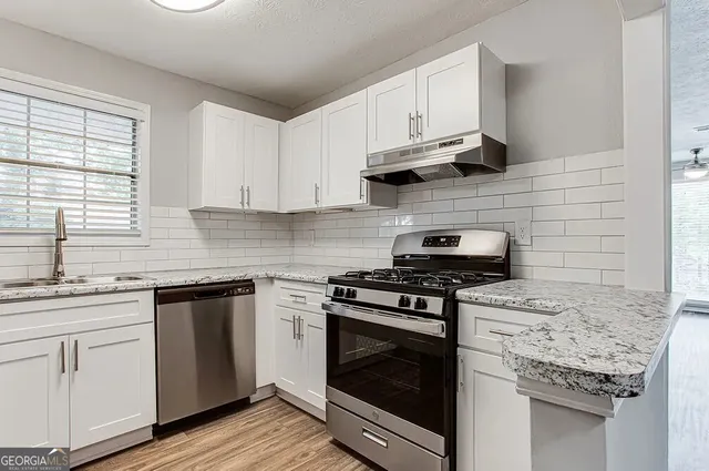 a kitchen with cabinets stainless steel appliances and a sink