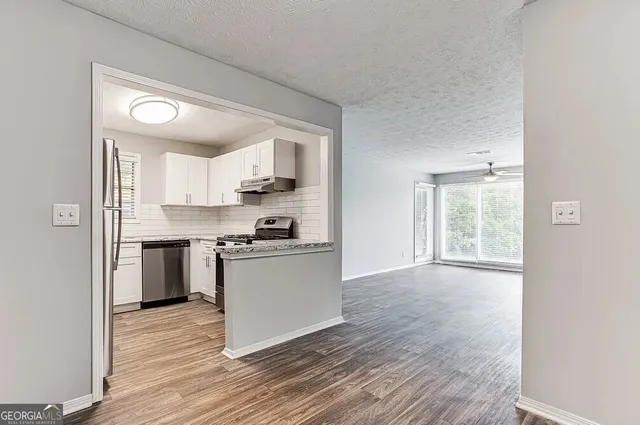 a kitchen with a refrigerator and a stove top oven