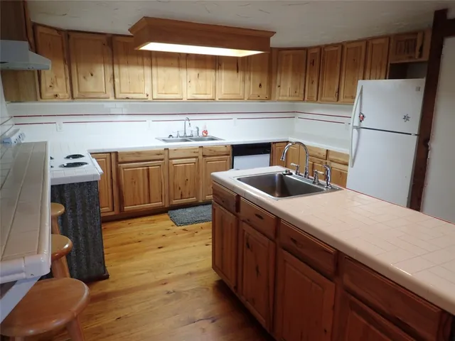 a kitchen with a sink refrigerator and cabinets