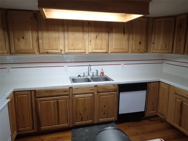 a kitchen with a sink cabinets and wooden floor