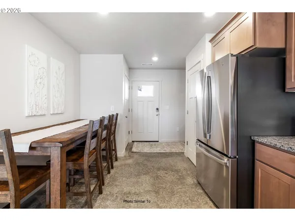 a view of kitchen with furniture and refrigerator