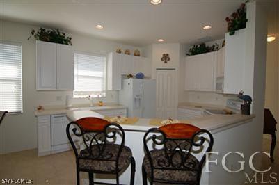 4744 Fairloop Run Lehigh Acres, FL 33973 - Photo 4 of 10 a kitchen with stainless steel appliances a sink and a refrigerator
