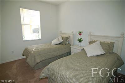 4744 Fairloop Run Lehigh Acres, FL 33973 - Photo 7 of 10 a bedroom with two beds and a window