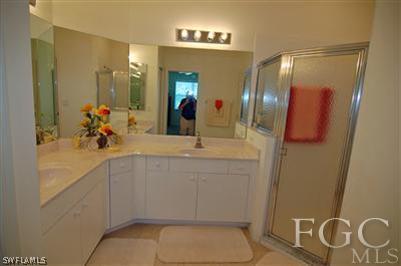 4744 Fairloop Run Lehigh Acres, FL 33973 - Photo 8 of 10 a bathroom with a toilet a sink and mirror