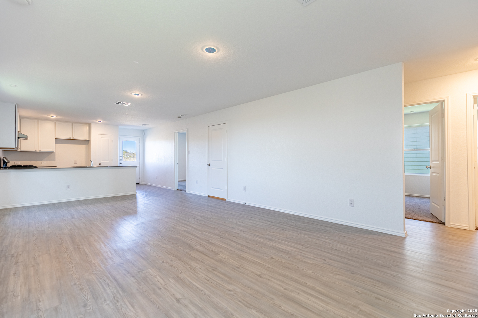 9143 Coronal Rings San Antonio, TX 78252 - Photo 4 of 30 an empty room with wooden floor and windows