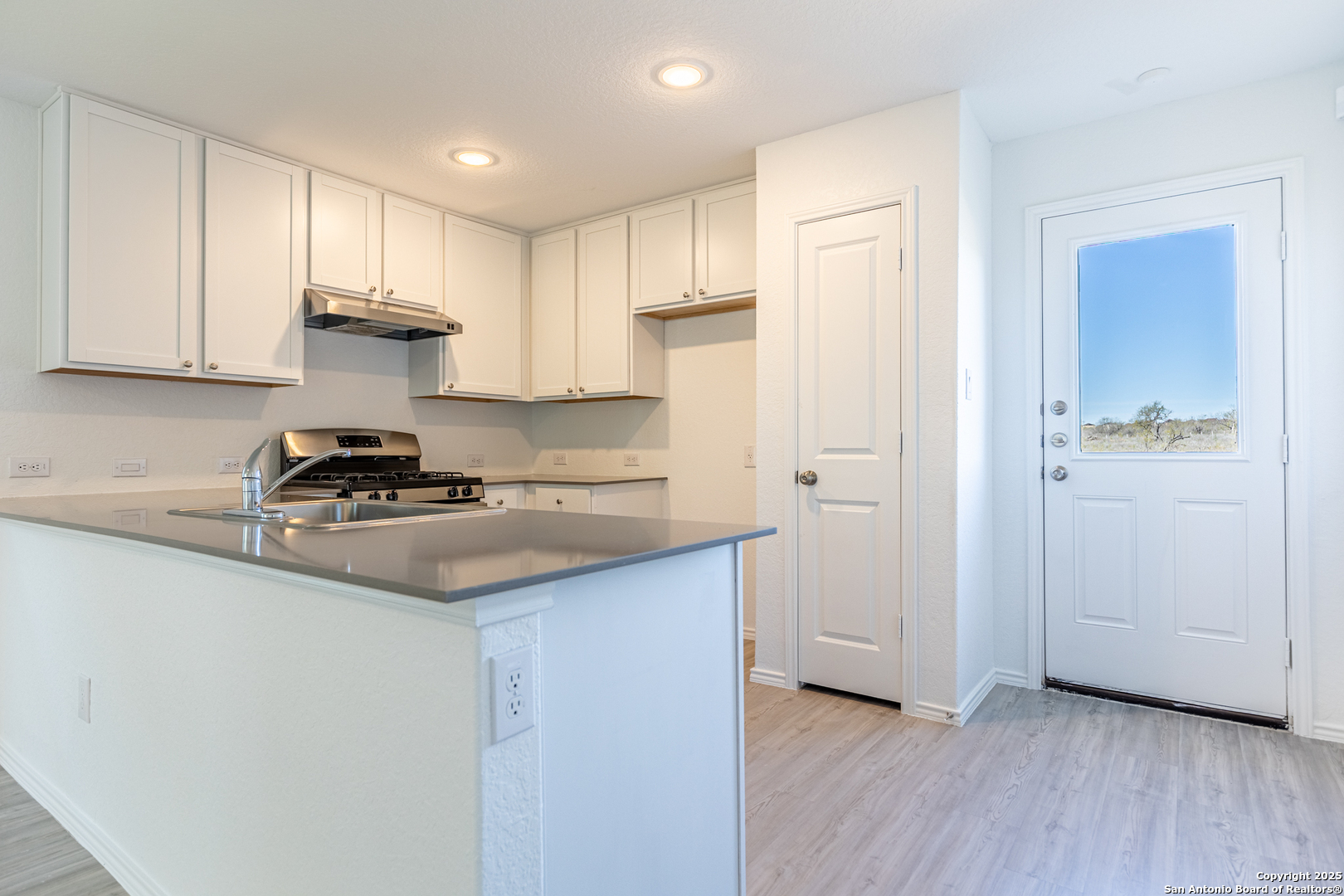 9143 Coronal Rings San Antonio, TX 78252 - Photo 8 of 30 a kitchen with a sink cabinets and wooden floor