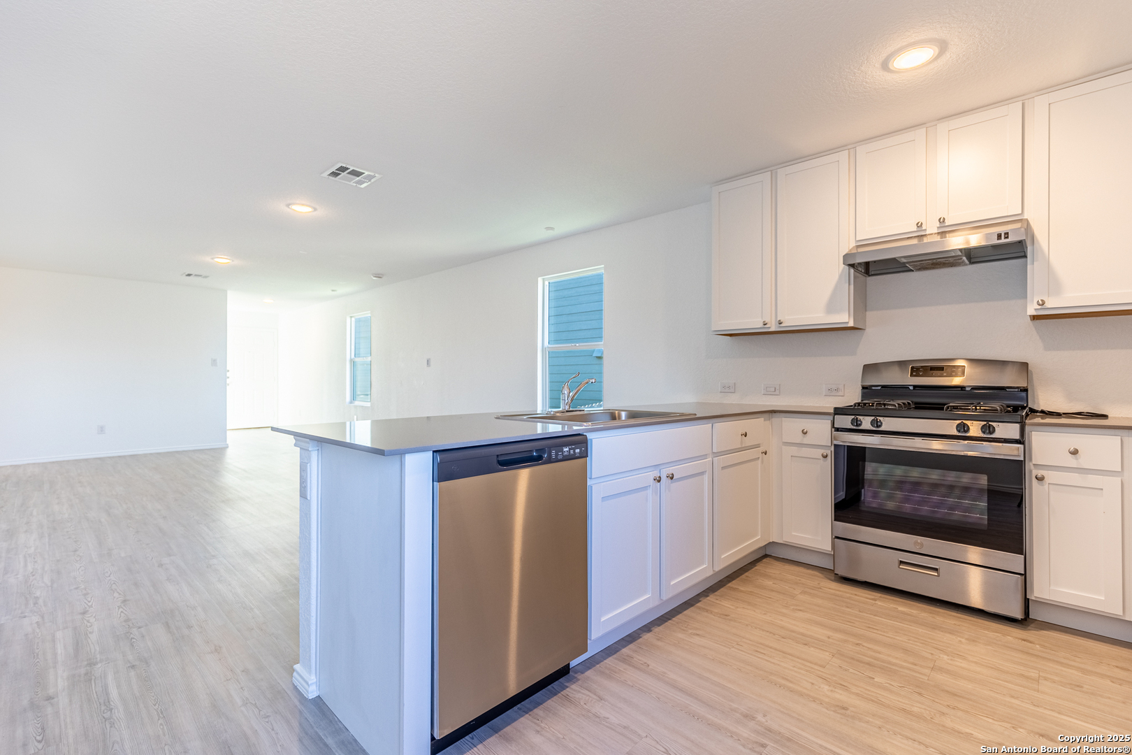 9143 Coronal Rings San Antonio, TX 78252 - Photo 9 of 30 a kitchen with stainless steel appliances granite countertop a stove and a sink