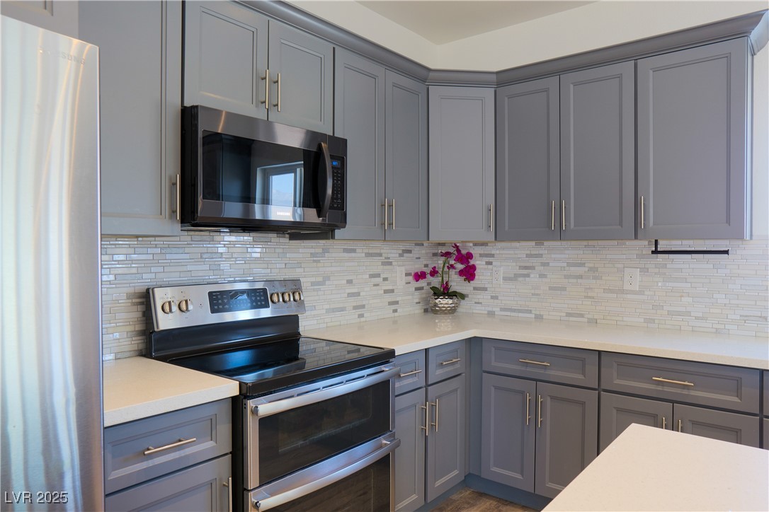 5400 Grain Mill Road Pahrump, NV 89061 - Photo 12 of 67 Kitchen with appliances with stainless steel finishes, gray cabinetry, and light countertops
