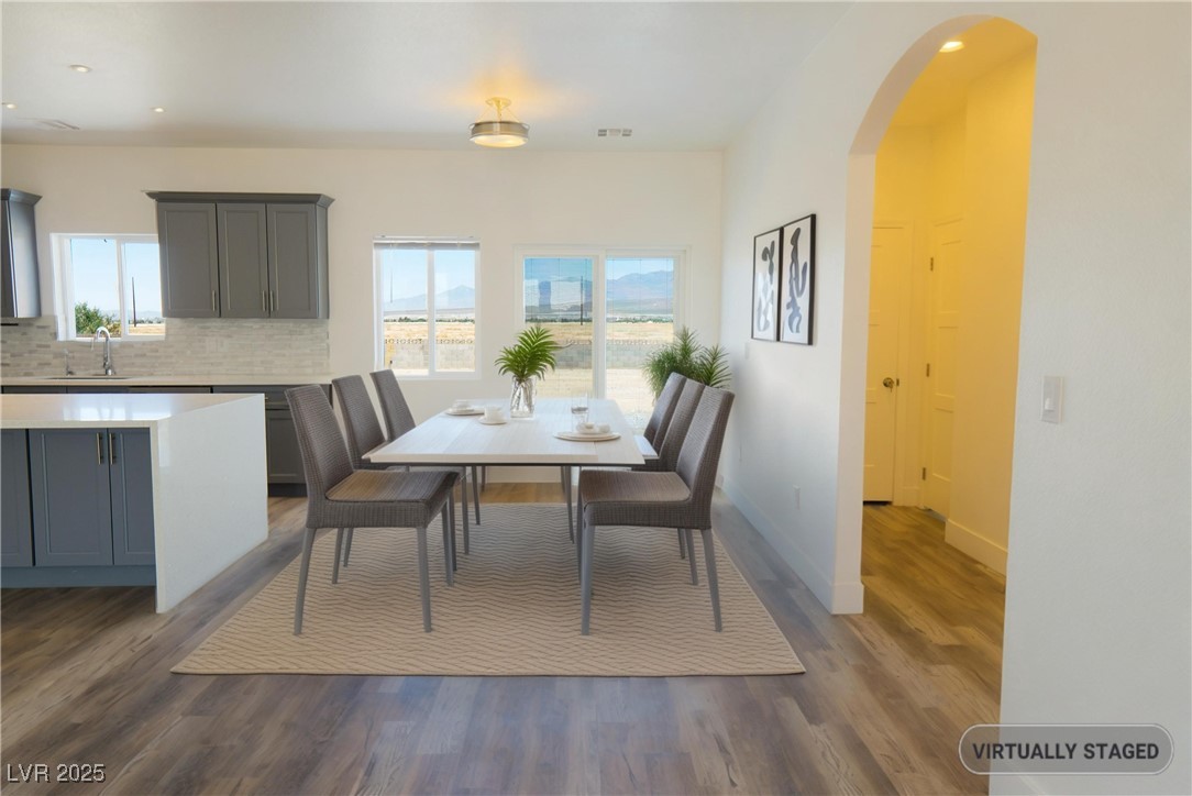 5400 Grain Mill Road Pahrump, NV 89061 - Photo 14 of 67 Dining room featuring dark wood-style flooring, arched walkways, recessed lighting, and baseboards