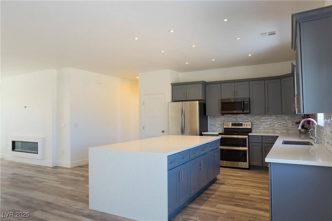5400 Grain Mill Road Pahrump, NV 89061 - Photo 15 of 67 Kitchen with stainless steel appliances, a sink, decorative backsplash, light wood-style flooring, and recessed lighting
