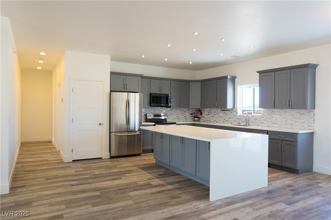 5400 Grain Mill Road Pahrump, NV 89061 - Photo 21 of 67 Kitchen featuring stainless steel appliances, gray cabinetry, a center island, decorative backsplash, and recessed lighting