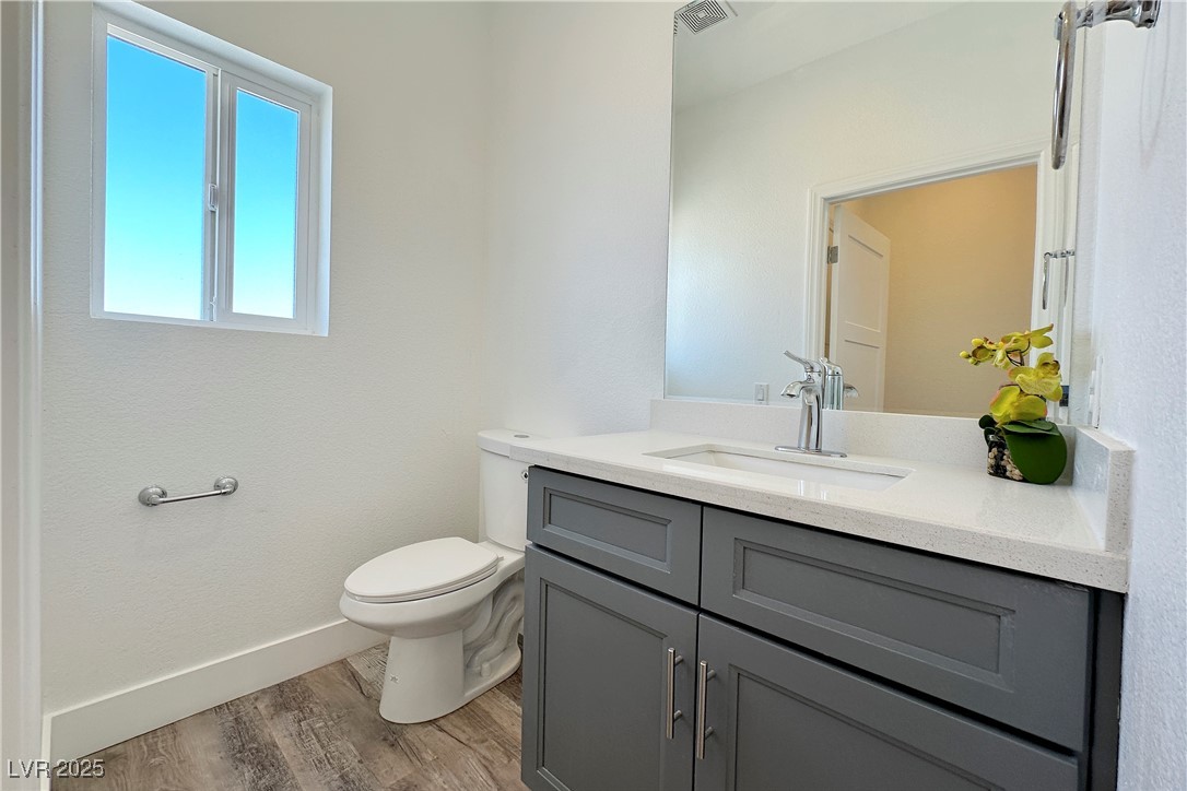 5400 Grain Mill Road Pahrump, NV 89061 - Photo 22 of 67 Bathroom with wood finished floors, toilet, vanity, and baseboards