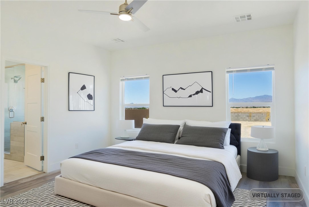 5400 Grain Mill Road Pahrump, NV 89061 - Photo 24 of 67 Bedroom with wood finished floors, a ceiling fan, baseboards, and ensuite bathroom