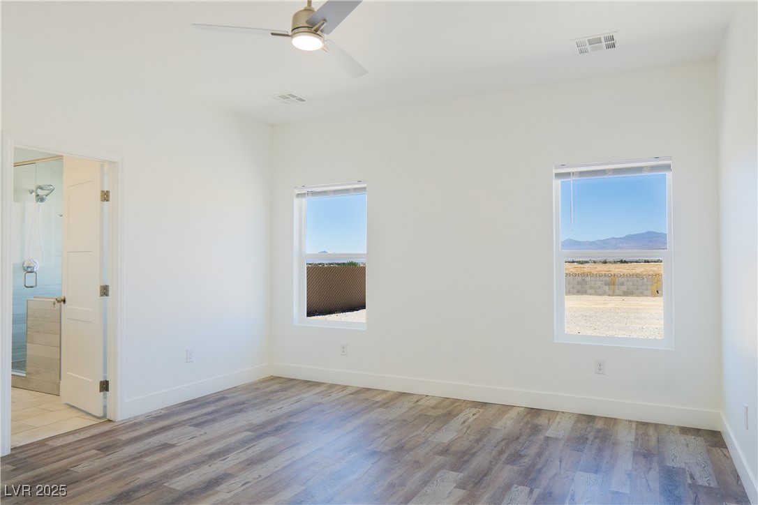 5400 Grain Mill Road Pahrump, NV 89061 - Photo 25 of 67 Empty room with wood finished floors, a ceiling fan, and baseboards
