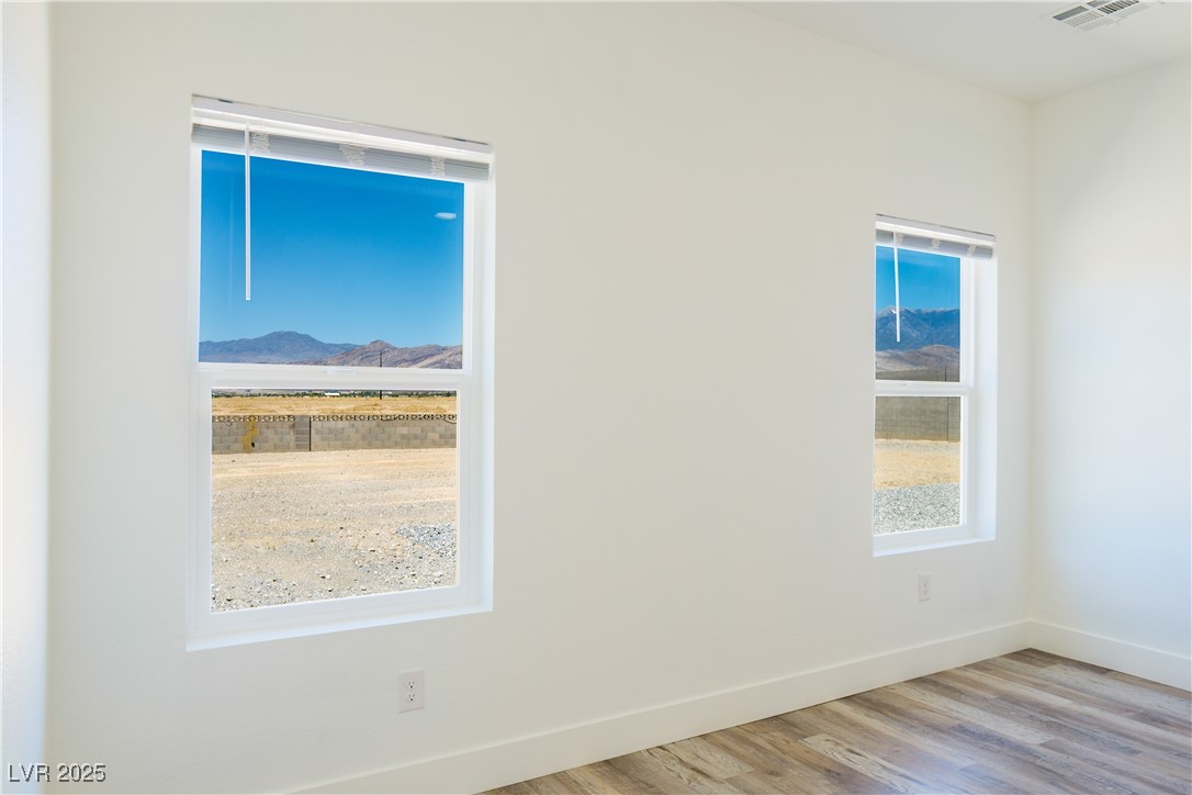 5400 Grain Mill Road Pahrump, NV 89061 - Photo 26 of 67 Spare room with wood finished floors, a mountain view, and baseboards