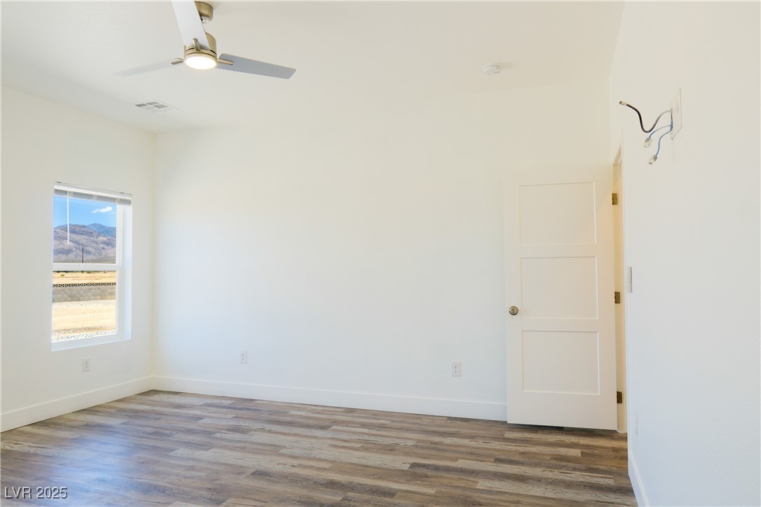 5400 Grain Mill Road Pahrump, NV 89061 - Photo 27 of 67 Spare room featuring wood finished floors, baseboards, and a ceiling fan