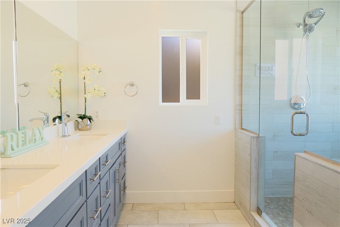 5400 Grain Mill Road Pahrump, NV 89061 - Photo 30 of 67 Bathroom with a stall shower, baseboards, tile patterned floors, and double vanity
