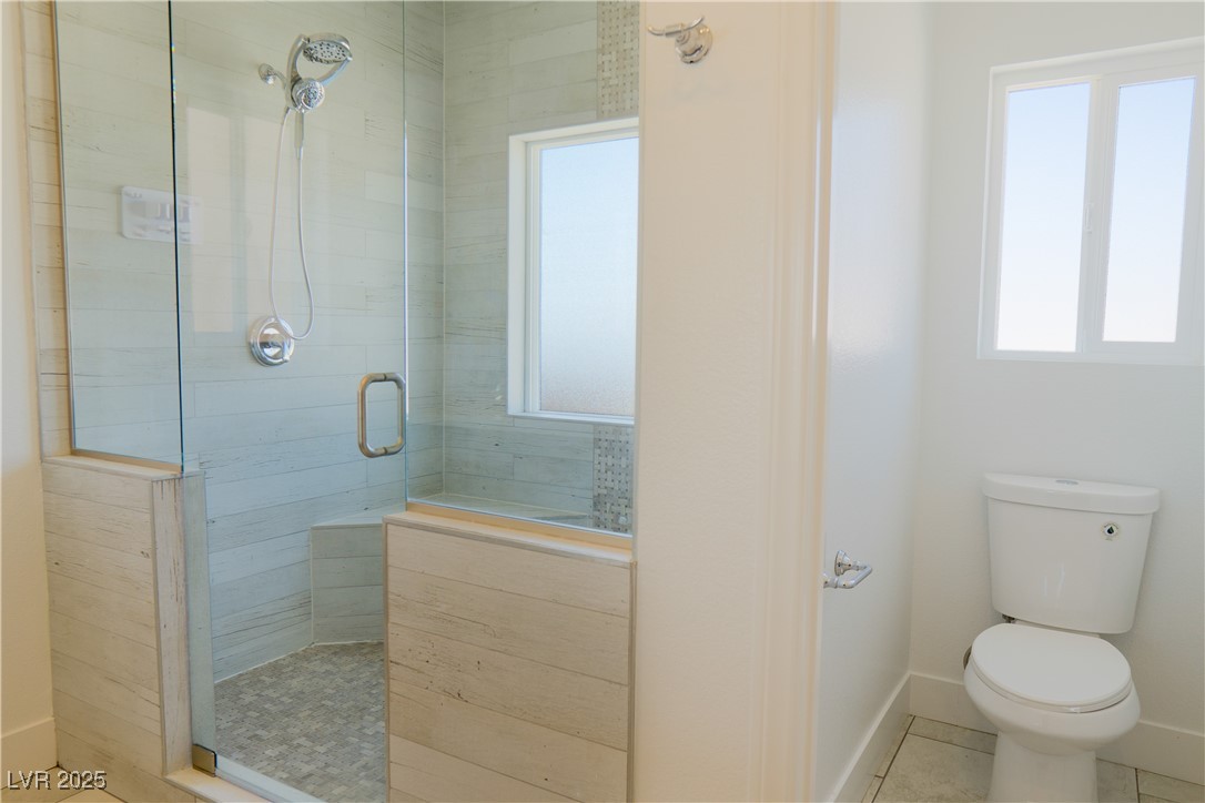 5400 Grain Mill Road Pahrump, NV 89061 - Photo 32 of 67 Bathroom featuring a shower stall, toilet, baseboards, and tile patterned floors