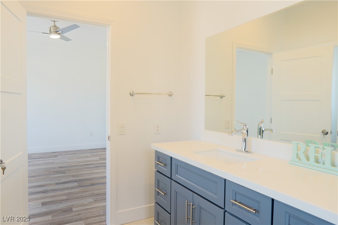 5400 Grain Mill Road Pahrump, NV 89061 - Photo 34 of 67 Bathroom featuring baseboards, a ceiling fan, vanity, and wood finished floors
