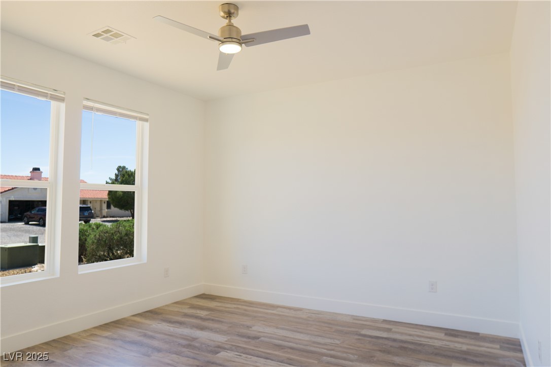 5400 Grain Mill Road Pahrump, NV 89061 - Photo 39 of 67 Spare room with baseboards, wood finished floors, and ceiling fan