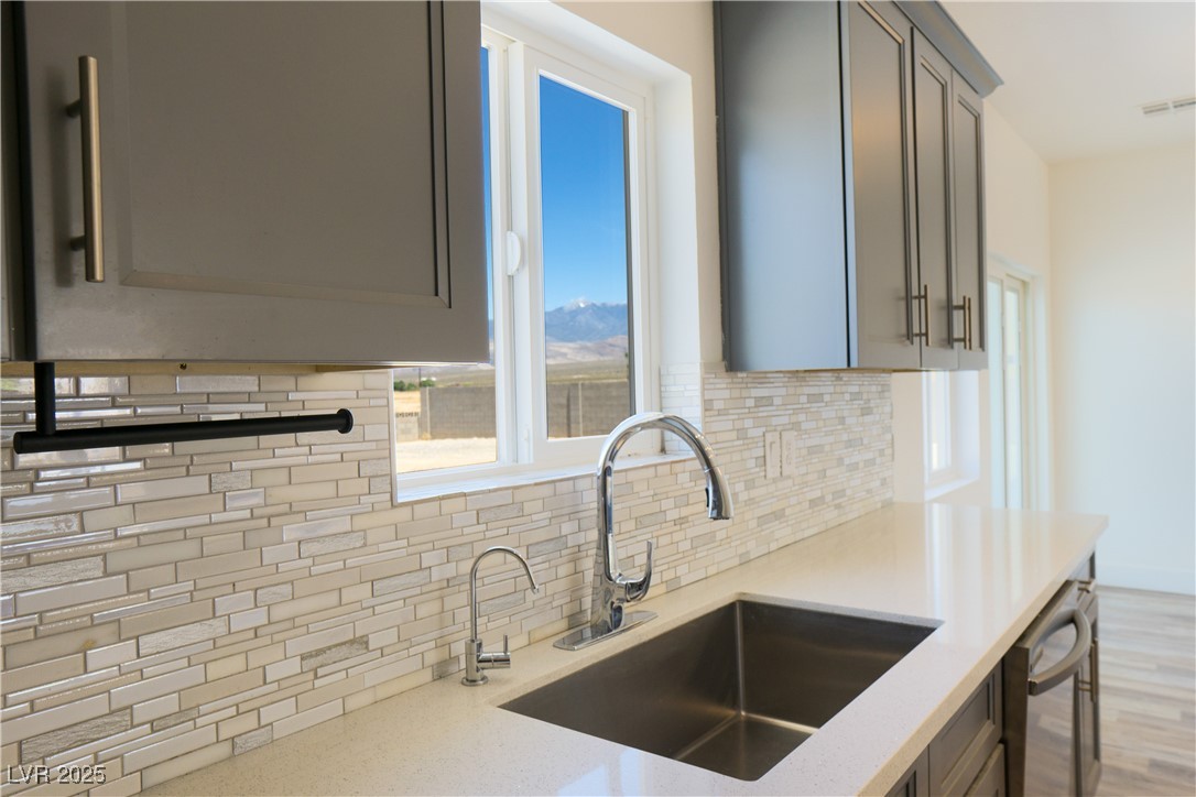 5400 Grain Mill Road Pahrump, NV 89061 - Photo 4 of 67 Kitchen featuring gray cabinetry, decorative backsplash, a sink, and dishwasher