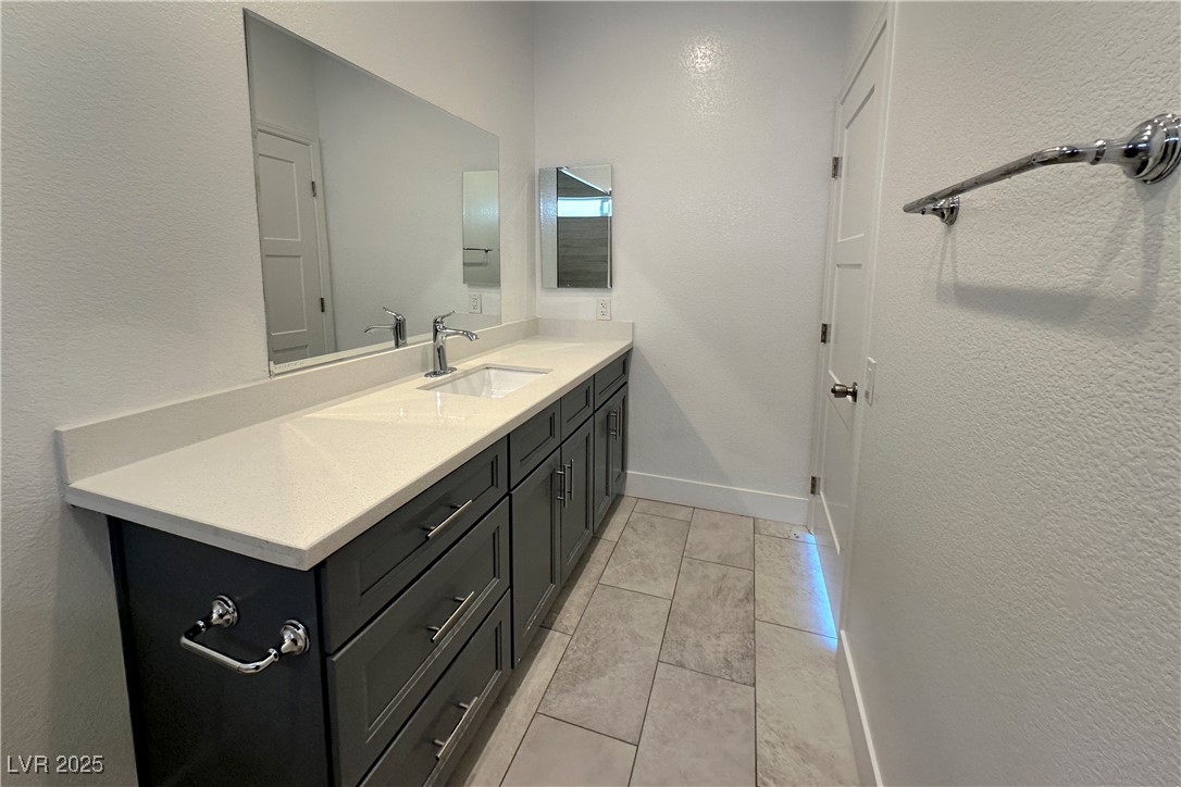 5400 Grain Mill Road Pahrump, NV 89061 - Photo 41 of 67 Bathroom with vanity, tile patterned flooring, baseboards, and a textured wall