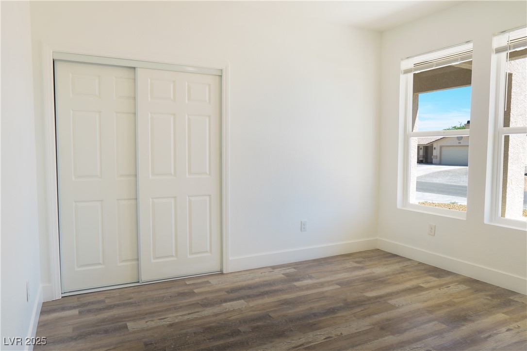 5400 Grain Mill Road Pahrump, NV 89061 - Photo 44 of 67 Unfurnished bedroom featuring dark wood-style flooring, a closet, and baseboards