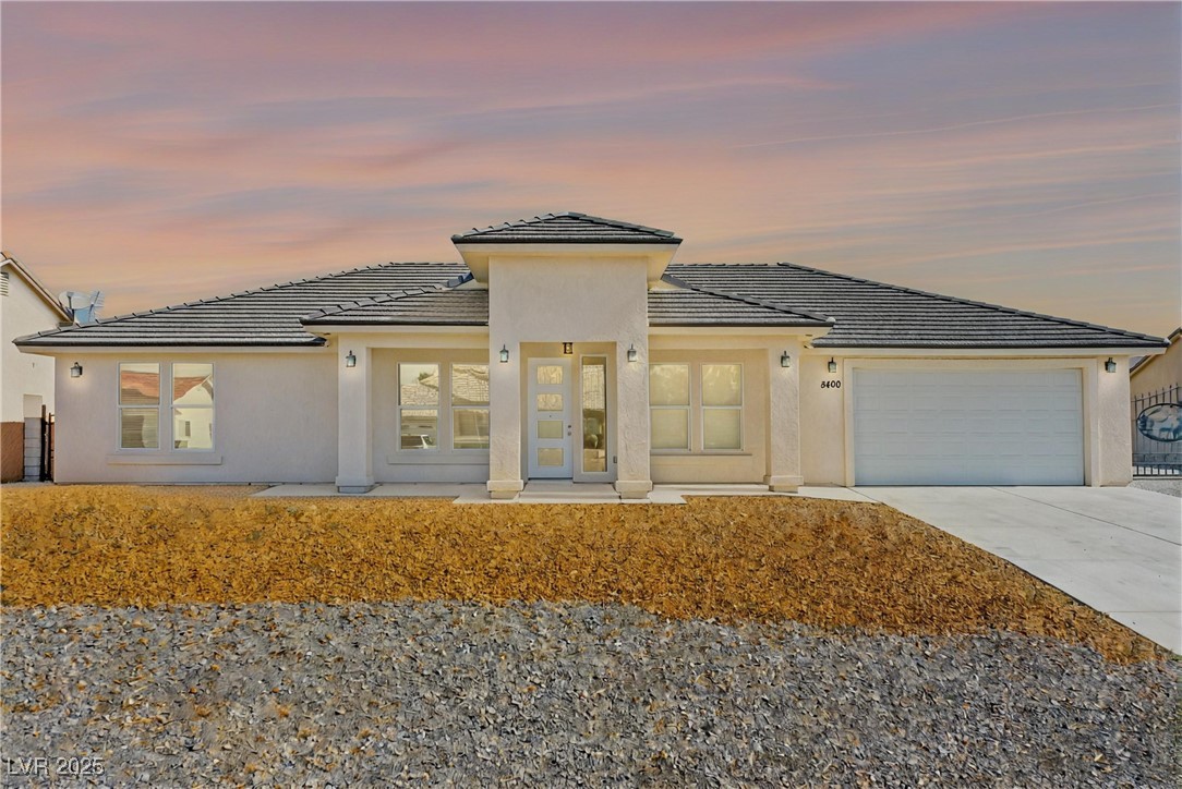 5400 Grain Mill Road Pahrump, NV 89061 - Photo 57 of 67 Prairie-style house with concrete driveway, a tile roof, an attached garage, and stucco siding