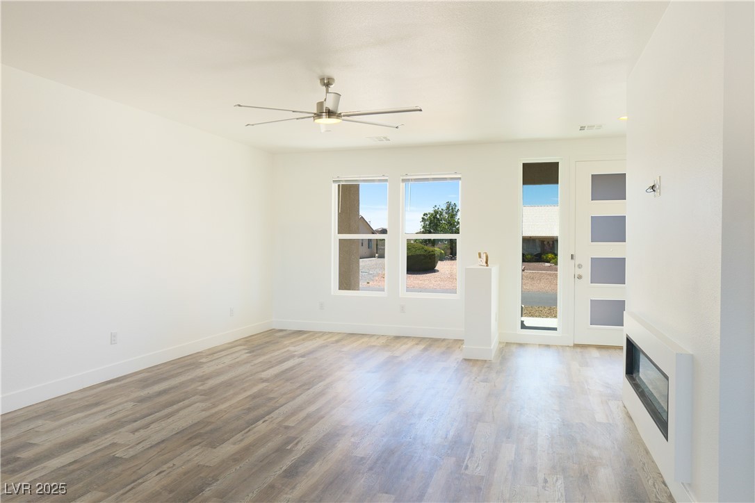 5400 Grain Mill Road Pahrump, NV 89061 - Photo 8 of 67 Unfurnished living room featuring wood finished floors, a ceiling fan, and baseboards