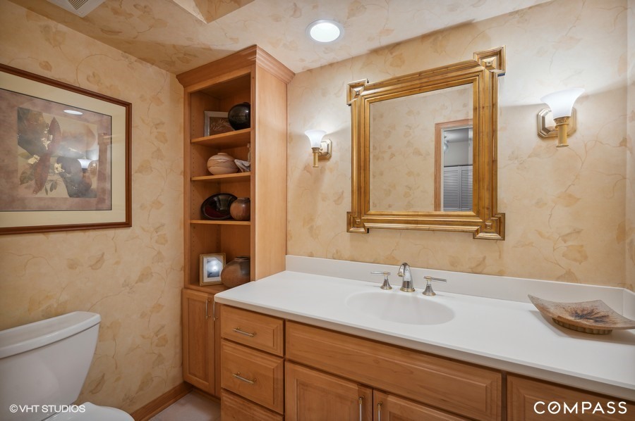 1119 Deerfield Road Deerfield, IL 60015 - Photo 8 of 19 a bathroom with a granite countertop sink a mirror and a toilet