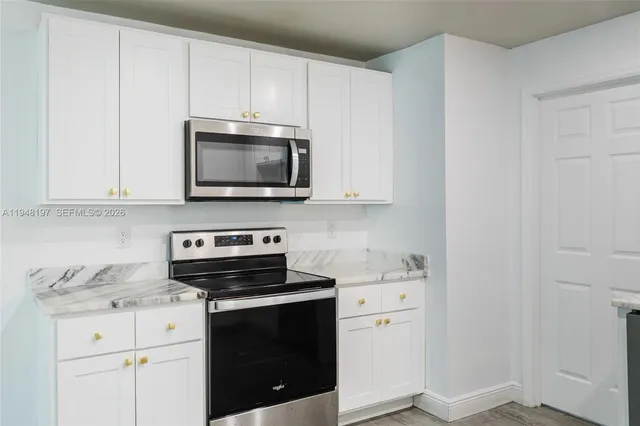 a kitchen with appliances a sink and cabinets