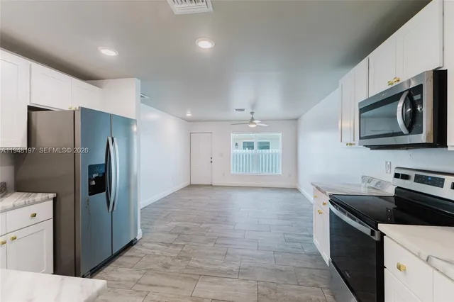 a kitchen with stainless steel appliances granite countertop a refrigerator and a stove top oven