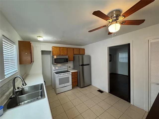 a kitchen with stainless steel appliances granite countertop a sink a stove and a refrigerator