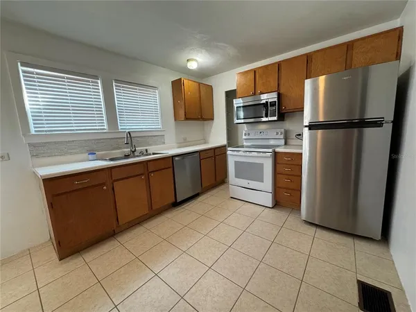 a kitchen with stainless steel appliances granite countertop a refrigerator sink and stove