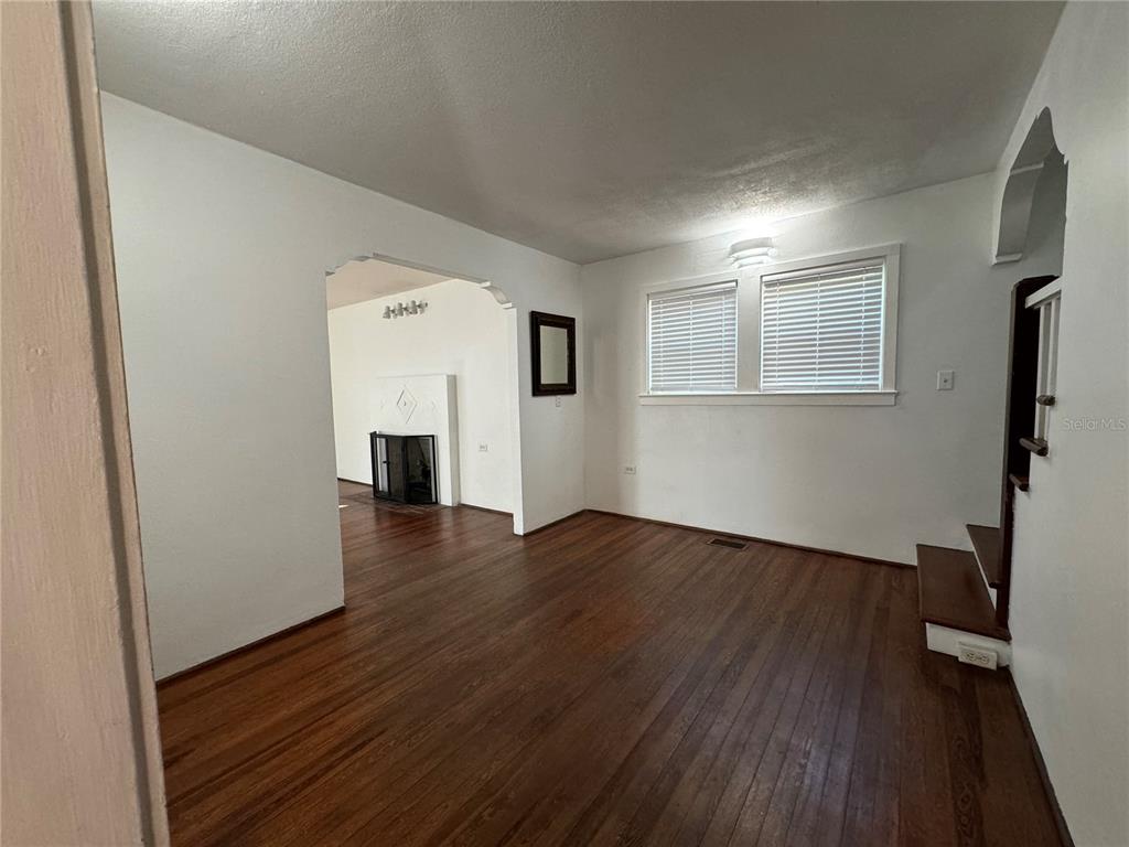 302 West Wall Street Frostproof, FL 33843 - Photo 21 of 37 an empty room with wooden floor and fireplace