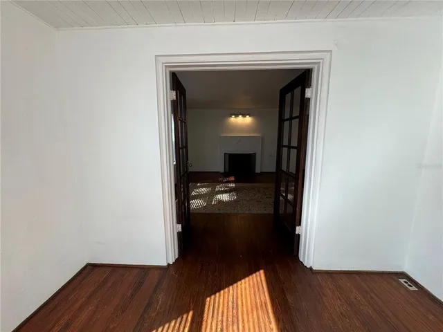 a view of a hallway view with wooden floor and a bathroom