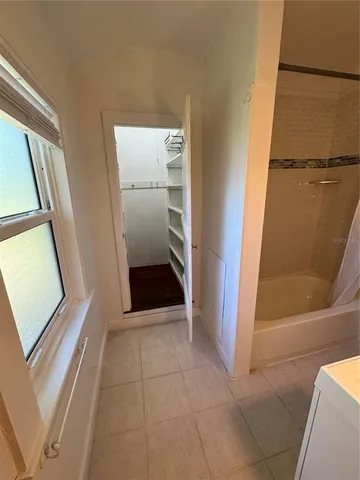 a view of an empty room and wooden floor and a kitchen