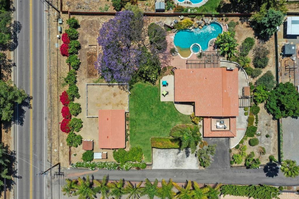 an aerial view of a house with a yard and a large pool