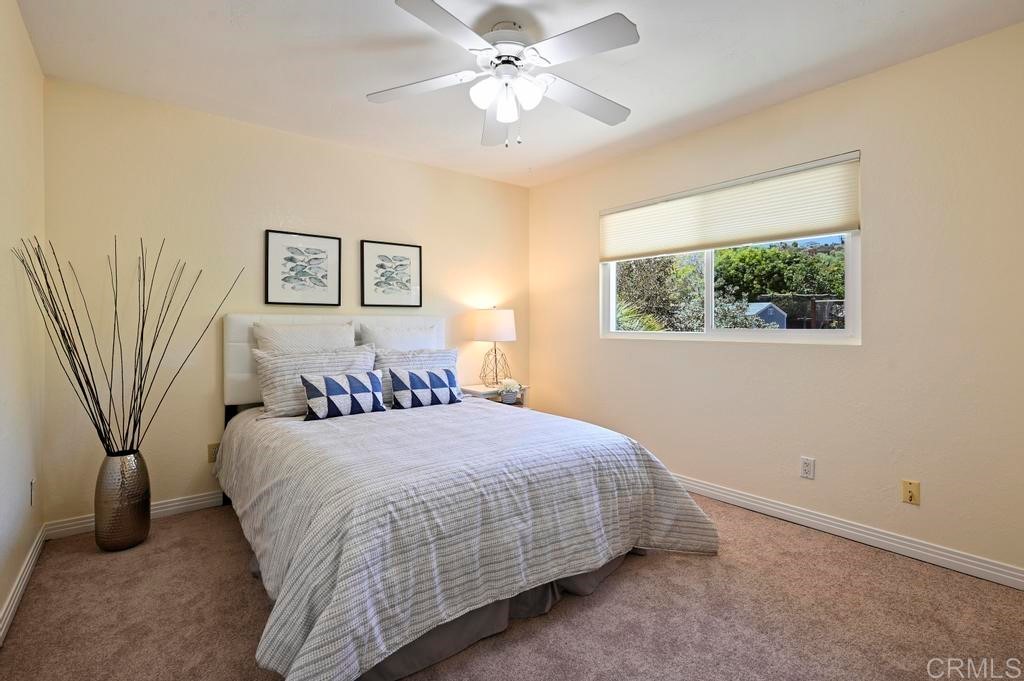546 Rancho Santa Fe Road Encinitas, CA 92024 - Photo 21 of 48 a bedroom with a bed and a chandelier