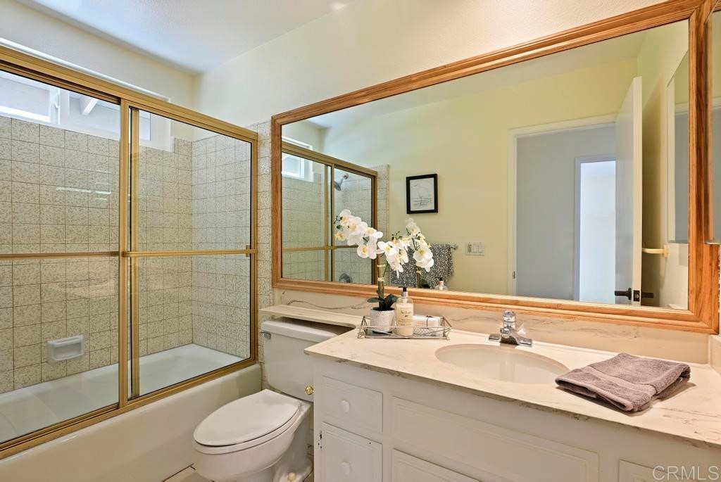 546 Rancho Santa Fe Road Encinitas, CA 92024 - Photo 23 of 48 a bathroom with a granite countertop sink toilet a large mirror a vanity and shower