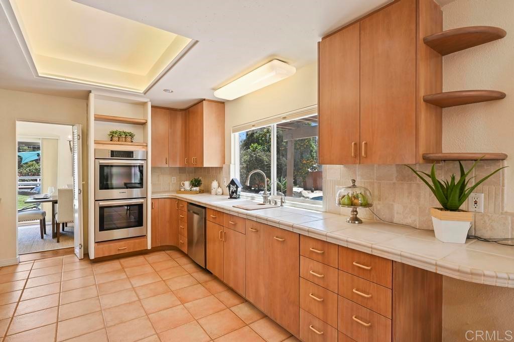 546 Rancho Santa Fe Road Encinitas, CA 92024 - Photo 9 of 48 a kitchen with stainless steel appliances a sink a stove and cabinets