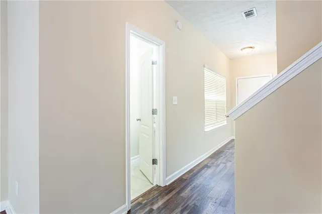 a view of a hallway with wooden floor and staircase