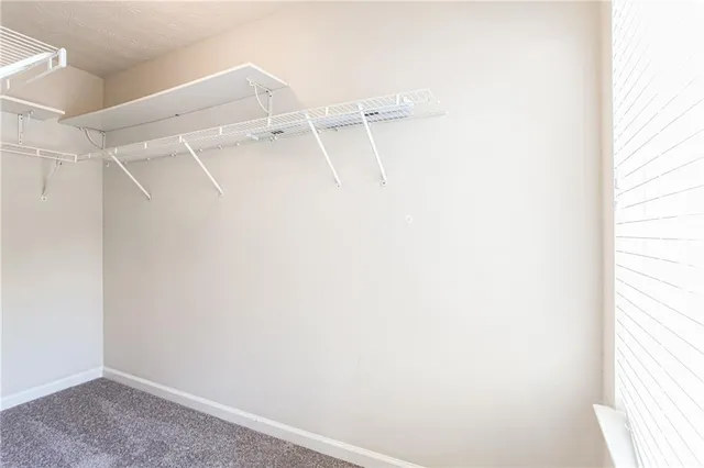 a view of walk in closet with empty racks