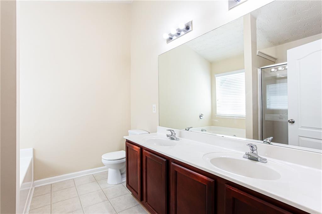 4628 McEver View Drive Sugar Hill, GA 30518 - Photo 19 of 30 a bathroom with a double vanity sink toilet and a mirror