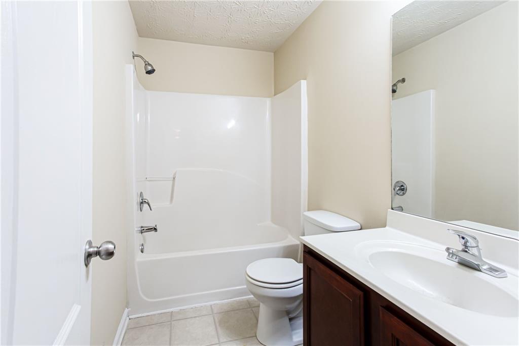 4628 McEver View Drive Sugar Hill, GA 30518 - Photo 25 of 30 a bathroom with a sink a toilet and shower
