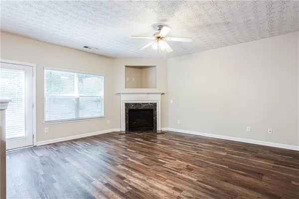 wooden floor fireplace and windows in an empty room